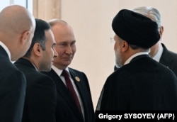 Президент России Владимир Путин (в центре) беседует с президентом Ирана Ибрахимом Раиси (справа) во время 6-го Каспийского саммита в Ашхабаде, 29 июня 2022 года