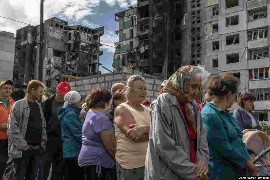 Local residents wait to receive humanitarian aid in front of a residential building that was damaged during a Russian attack in Borodyanka, Ukraine.