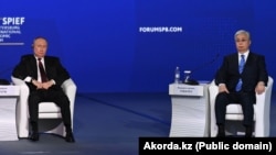 Қазақстан президенті Қасым-Жомарт Тоқаев (оң жақта) және Ресей басшысы Владимир Путин Санкт-Петербург экономика форумында. 17 маусым 2022 жыл.