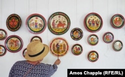 Natalya Rybak explains the symbolism of some of her art on plates in Petrykivka. The sturdy women, she explains, indicate a successful farm that keeps its owners well-fed.