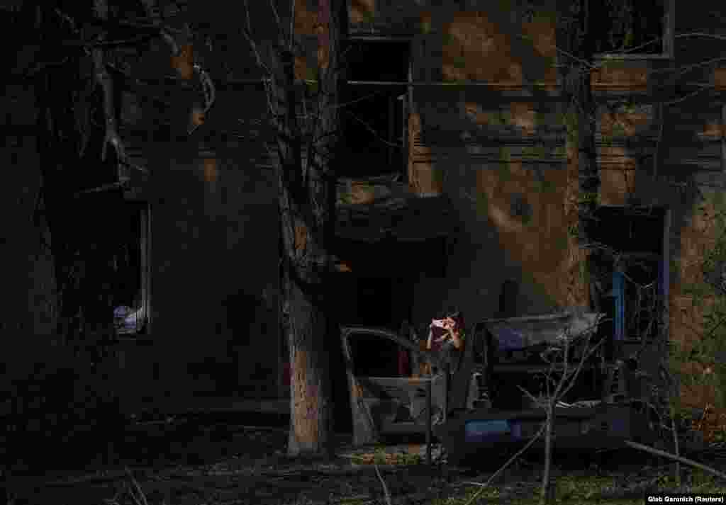 Žena fotografiše razaranja izazvana raketnim udarom u Kramatorsku. &nbsp;