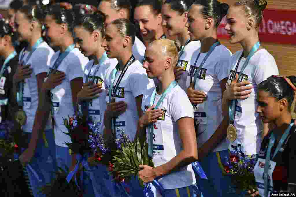 Team Ukraine listens to their national anthem after winning the gold medal in the final of the free combination of artistic swimming at the 19th FINA World Championships in Budapest on June 20.