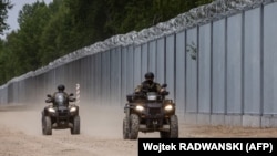 Pripadnici Službe za graničnu kontrolu Poljske patroliraju uz ogradu koja je podignuta ka Belorusiji, jun 2022. 