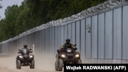 Polish border guards patrol along a section of the border wall in northeastern Poland.