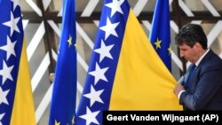 Član protokola namešta zastavu Bosne i Hercegovine pre dolaska na samit EU u Briselu, 23. juna 2022.