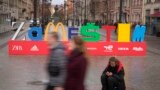 People walk past an installation that reads "Zamestim" (We Will Replace), assembled from the first letters of brands that left Russia in response to its invasion of Ukraine, in St. Petersburg in April.