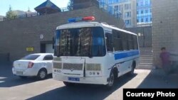 Полицейский автобус припаркован перед домом, где останавились безработные из Жанаозена. Нур-Султан, 24 июня 2022 года