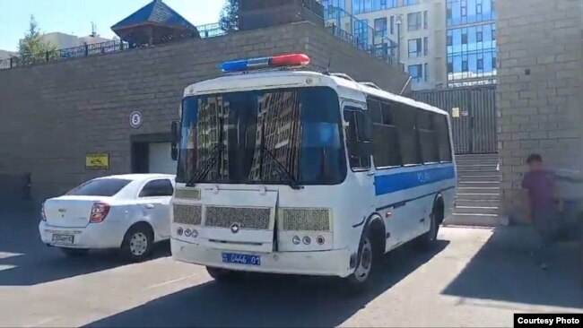 Полицейский автобус припаркован перед домом, где останавились безработные из Жанаозена. Нур-Султан, 24 июня 2022 года