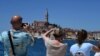 Turisták fotóznak az Isztriai-félsziget nyugati partján fekvő Rovinj városában 2022. június 11-én
