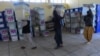 Afghanistan Independent Election Commission workers carry ballot boxes into a warehouse after ballots were counted during the country's legislative election, in Herat on October 21.