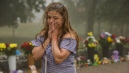 A woman cries near an impromptu memorial of flowers that have been brought to the Amstor shopping mall in Kremenchuk which was destroyed in a deadly missile strike on June 27. 