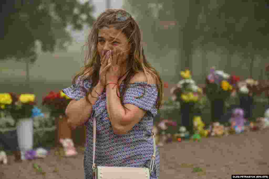 A woman cries near flowers brought to &nbsp;the destroyed Amstor shopping mall in Kremenchuk, Ukraine, on June 28, after a Russian missile strike killed at least 18 people the day before.&nbsp;