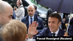 Emmanuel Macron francia elnök köszönti támogatóit, miután leadta szavazatát a francia parlamenti választások második fordulójában a Le Touquet-Paris-Plage-i szavazóhelyiségben 2022. június 19-én