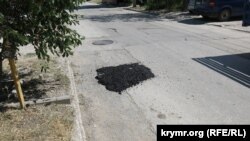 Наспех сделанный ямочный ремонт асфальтового покрытия городской улицы
