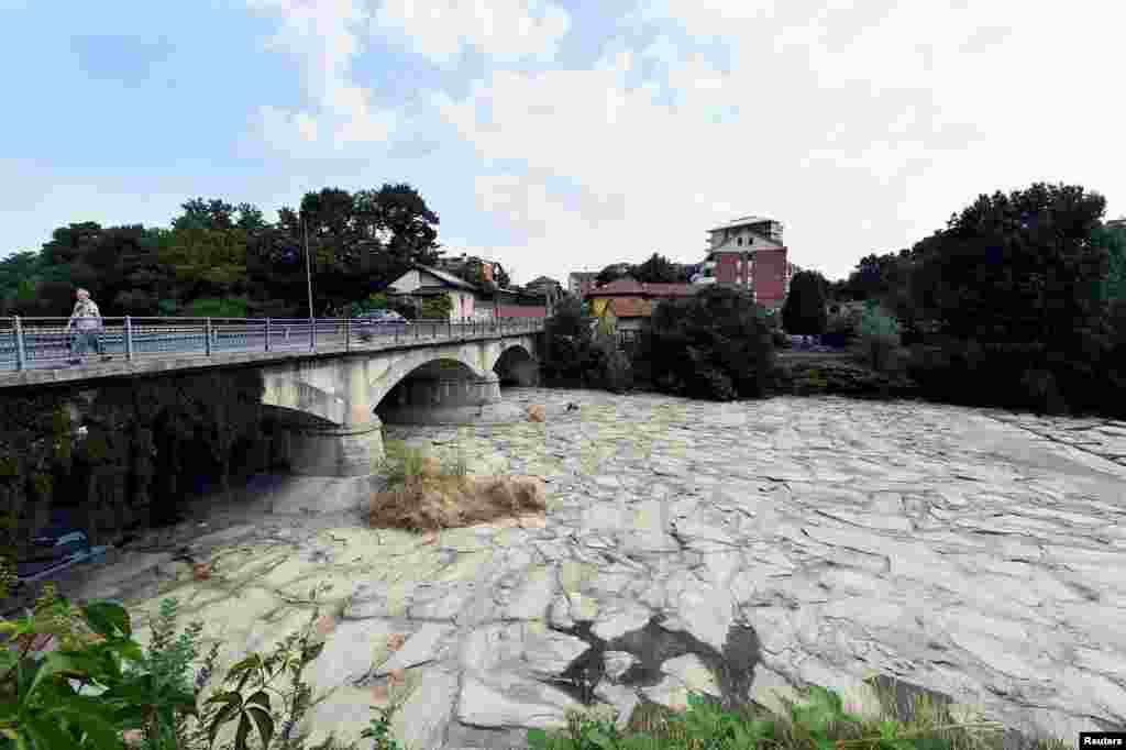 Albia pietruită a râului Sangone din Torino, Italia, văzută pe 19 iunie. În unele orașe din nordul Italiei, au fost adoptate măsuri extraordinare de economisire a apei, interzicându-li-se, de pildă, frizerilor să spele părul clienților de două ori.