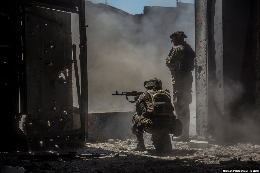 Ushtarët ukrainas shikojnë se si një tank (që nuk shihet në foto) qëllon drejt trupave ruse në një zonë industriale të Severodonjeckut.