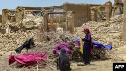 Afghan quake survivors dry clothes on some old branches in the Bermal district of Paktika Province on June 23. (file photo)