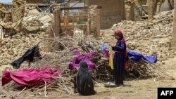 دو کودک در ولایت پکتیکا در بیرون از خانه های شان که در اثر زلزله ویران شده نشسته اند