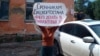 Vera Popova of Ufa, who is a distant relative of a conscript, holds a placard telling recruits that they have no business being sent to areas near the front lines with Ukraine.