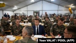 Emmanuel Macron elnök francia és belga katonákkal vacsorázik a Konstanca városához közeli Mihail Kogălniceanu légi bázison 2022. június 14-én