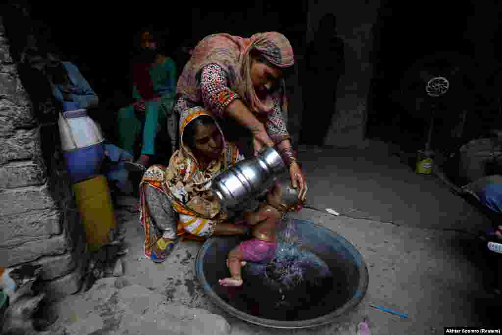 Rehmat, 30, helps Razia, 25, cool her 6-month-old daughter, Tamanna, during the heat wave in Jacobabad.&nbsp; &nbsp;