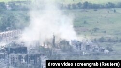 Smoke from artillery strikes rises over damaged buildings amid fighting in Toshkivka, in Ukraine's Luhansk region, on June 19.