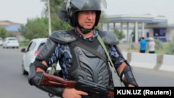 An Uzbek law enforcement officer guards on a street in Nukus on July 3. 