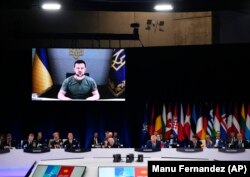 Președintele Ucrainei, Volodimir Zelenski, se adresează liderilor prin intermediul unui ecran video în timpul unei mese rotunde la un summit NATO de la Madrid, Spania, miercuri, 29 iunie 2022.