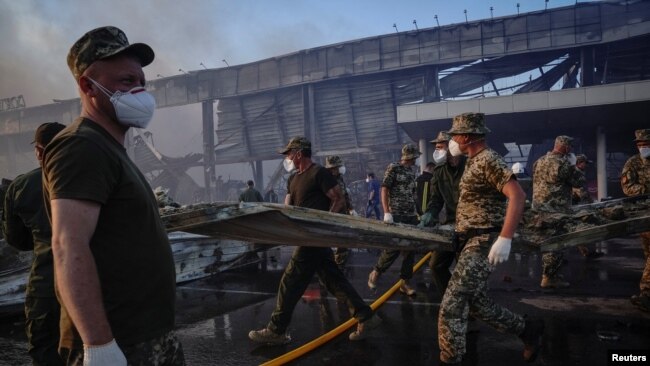 Rescue services work at the site of a shopping mall hit by a Russian missile strike in Kremenchuk on June 27.