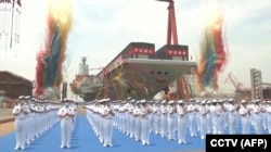 Кадр из видео, опубликованного китайской государственной телерадиокомпанией CCTV, с церемонии спуска на воду авианосца Народно-освободительной армии (НОАК) «Фуцзянь» на верфи в Шанхае. Китай, 17 июня 2022 года