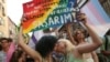 Dvije žene se ljube dok drže plakat na kojem piše na turskom: "Živim slobodno. Ko je budala koja će me staviti u lance? Bio bih šokiran" tokom marša LGBTQ ponosa u Istanbulu, Turska, u nedjelju, 26. juna 2022. 