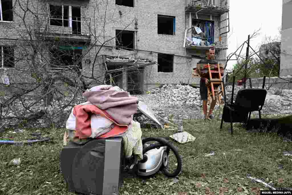 Stanovnik Časiv Jara izvlači svoje preostale stvari iz raketirane zgrade 10. jula.