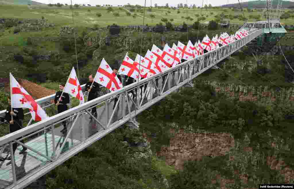 Flag-bearing men walk on the bridge during the opening ceremony. Dashbashi Canyon is around two hours&#39; drive west of Tbilisi.&nbsp;