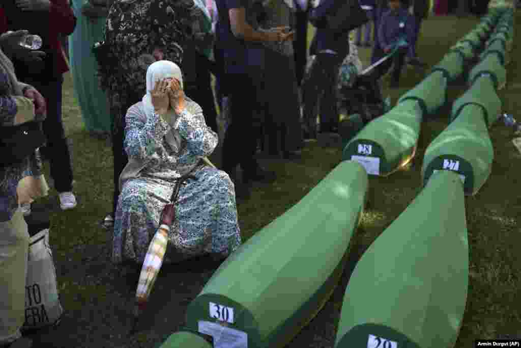 Bahta Aljic weeps next to a coffin containing her husband&#39;s newly identified remains.