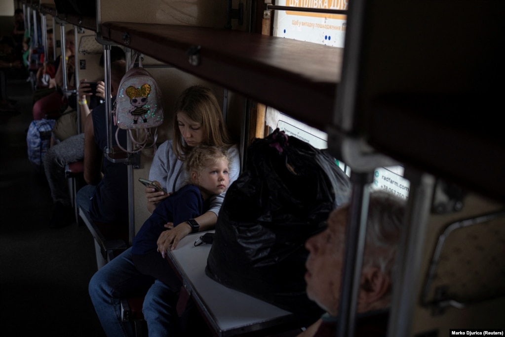 Me një fëmijë në prehër, një grua kontrollon telefonin e saj ndërsa treni udhëton drejt perëndimit. Gazetarët e Radios Evropa e Lirë në rajon kanë folur me shumë njerëz, të cilët, pavarësisht rrezikut, hezitojnë t'i braktisin shtëpitë e tyre. Vendimin për t'u larguar nga shtëpitë e tyre disa e marrin në minutën e fundit.