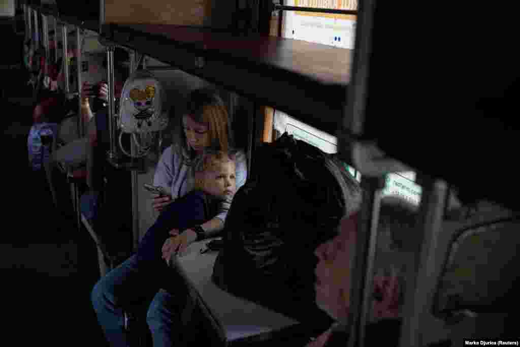 Cradling a child, a woman checks her phone as the train heads west. RFE/RL reporters in the region have spoken to many people who, despite, the risks, are reluctant to abandon their homes. Some leave the decision until the last minute, while some leave it too late.