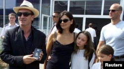 Bono Vox, vođa irske grupe U2, pokazuje svoj bh. pasoš nakon što je stigao na sarajevski aerodrom u pratnji supruge i kćeri, 25. august 2000.