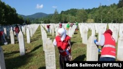 Volonteri čiste nadgrobne spomenike u Memorijalnom centru Srebrenica-Potočari, 18. juna 2022.