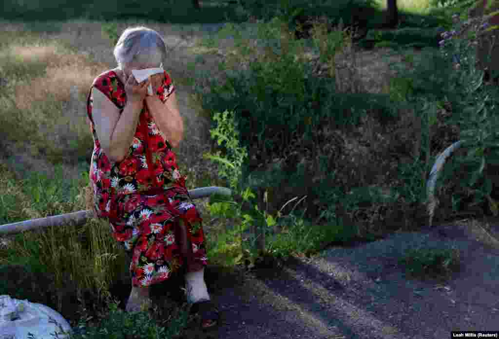 Anna Satanovskaya, 84, takes in the sudden loss of her husband who was killed moments before after apartment buildings were hit multiple times by Russian shelling in Kharkiv on June 27.