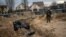 A Ukrainian soldier stands next to a mass grave with bodies of civilians, who according to residents were killed by Russian soldiers in Bucha, Kyiv region, on April 6.