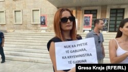 Një gazetare duke protestuar në Tiranë.