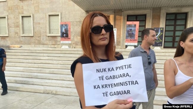 Një gazetare duke protestuar në Tiranë.