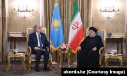 Kazakh President Qasym-Zhomart Toqaev (left) meets with Iranian President Ebrahim Raisi in Tehran on June 19.