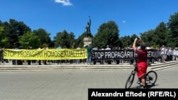 Un trecător filmează manifestația anti LGBT+ din Chișinău, 19 iunie 2022