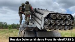 A Russian crew prepares rockets for a "Hurricane" multiple-launch rocket system.