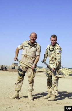 Подполковник Мик Райан (справа) и полковник Тео Влеуглес начинают копать фундамент для Австралийского центра подготовки навыков в Тарине, сентябрь 2006 года