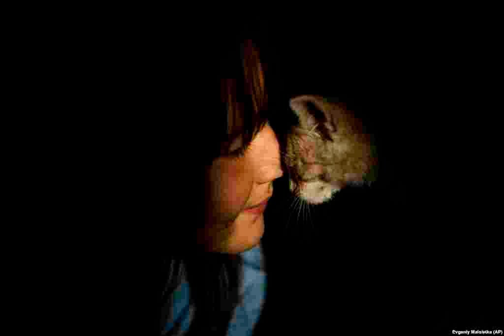 A 9 éves Diana simogatja macskáját romos otthonukban