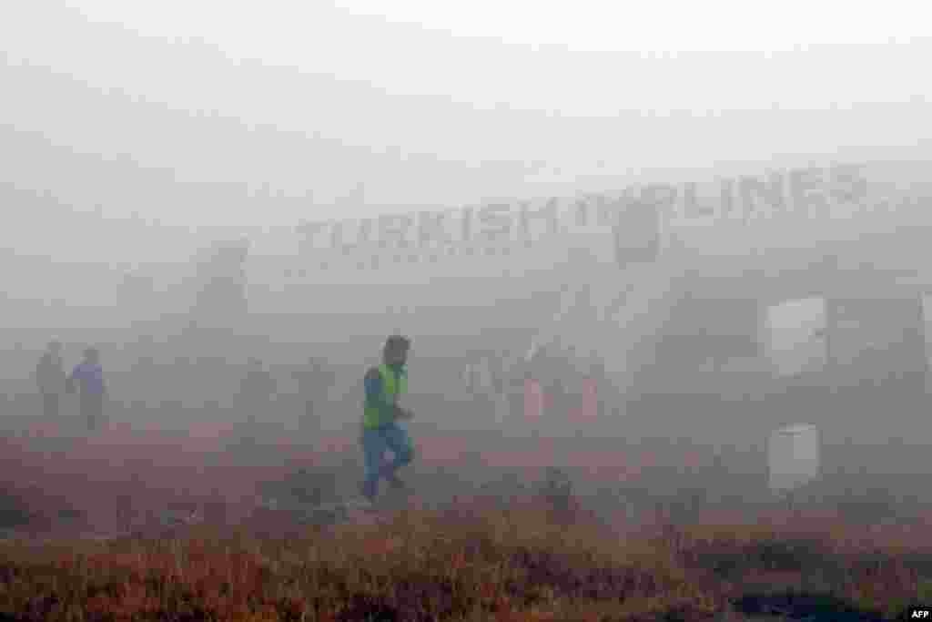 Passengers leave a Turkish Airlines plane that skidded off the runway on landing at Kathmandu airport in Nepal. No one on board was injured, although one witness described how terrified passengers leaped from their seats as the cabin filled with smoke after the plane skidded to a halt. (AFP/Dikesh Malhotra)