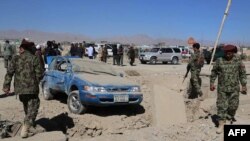 Security forces inspect the site of a roadside explosion detonated by a remote control bomb in southeastern Afghanistan.