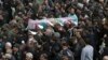 Iranian policemen carry a the coffin of colleague a colleague who was one of three officers killed last month when a bus rammed into them in February. 